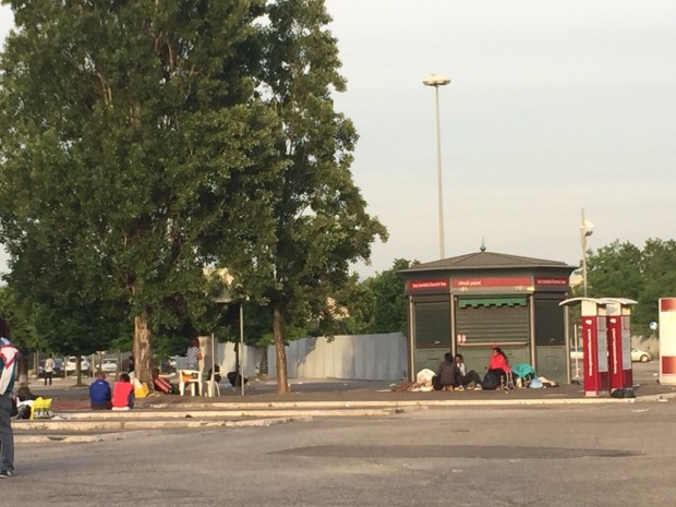 Alcune persone nel parcheggio davanti al campo di Ponte Mammolo, dopo lo sgombero 